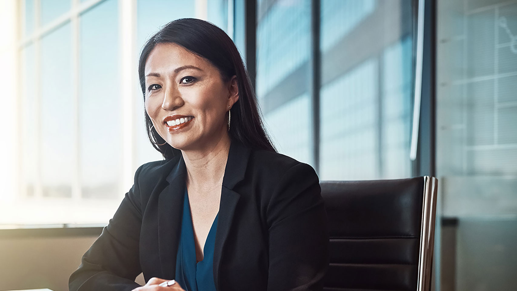 Businesswoman sitting in a chair smiling at the camera