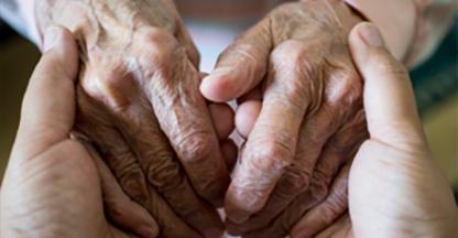 A young pair of hands holding an older pair of hands