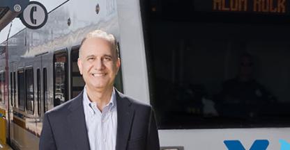 Businessman standing in front of a public transit train