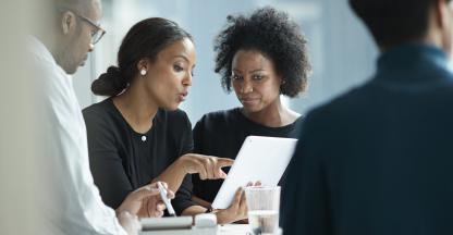 Black lawyers sitting around a table talking.