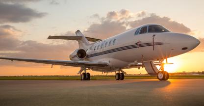 Private jet on the runway in front of the sunset