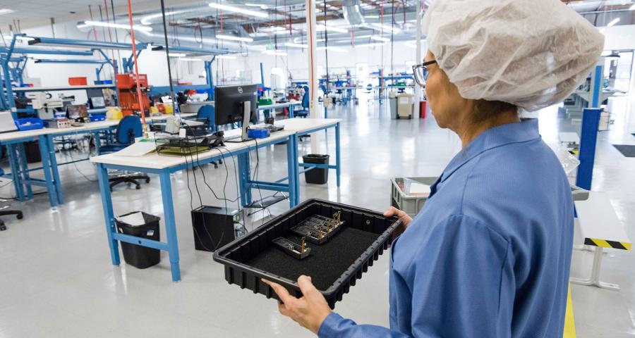 Woman carrying a tray in a lab