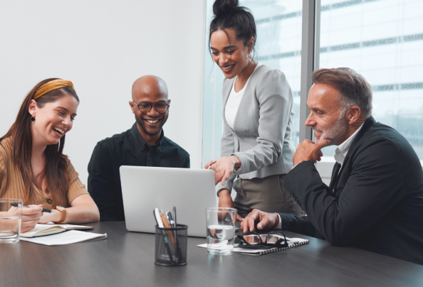 Business meeting with four people looking at a laptop